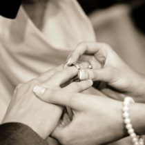 A womans hand inserting a ring to a mans hand